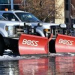 Białe pickupy z pługami śnieżnymi przygotowane do odśnieżania dróg