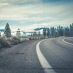 Kręta droga krajowa wśród lasu iglastego w pochmurny dzień