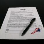 Umowa leasingu z długopisem i brelokiem z flagą USA na czarnym biurku