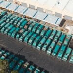 Flota turkusowych ciężarówek zaparkowanych przy magazynie z lotu ptaka